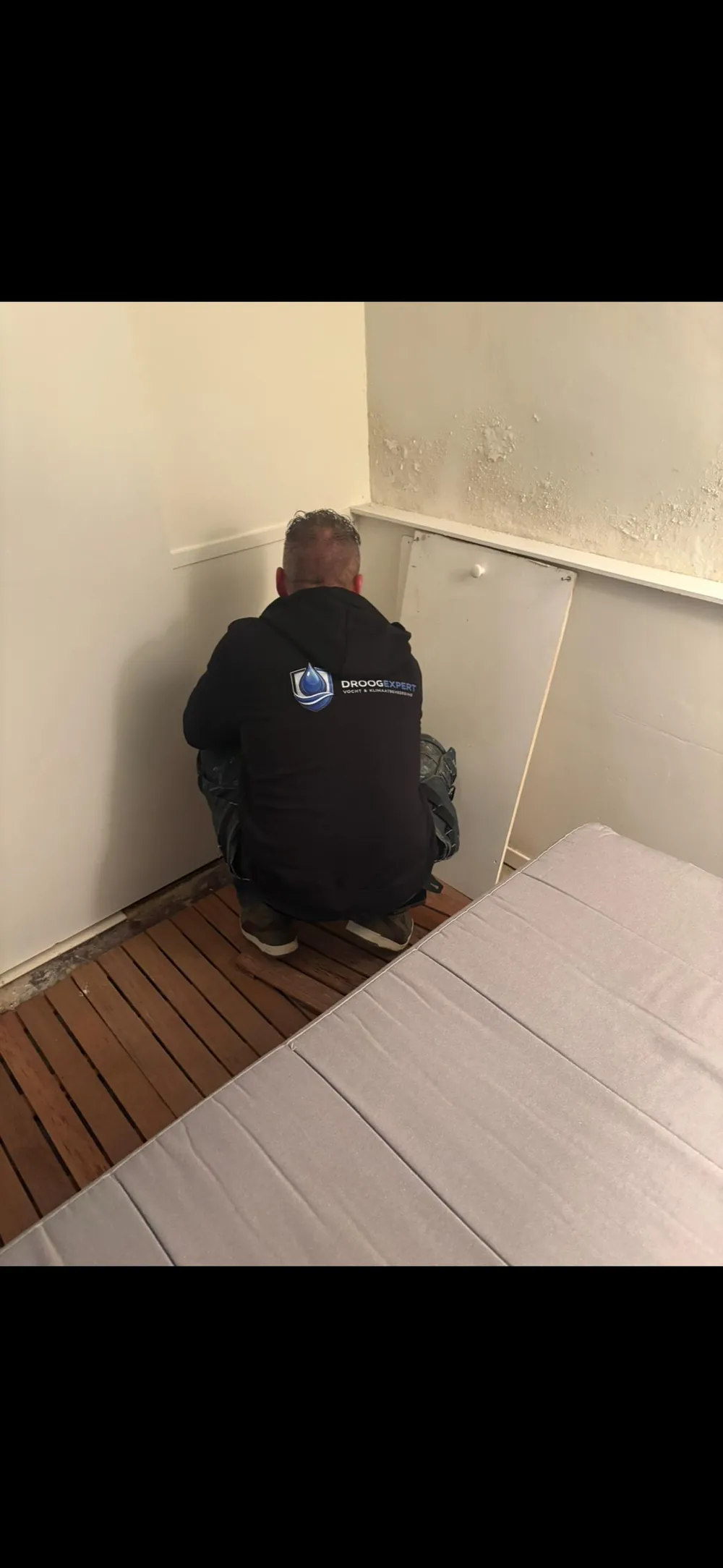 Medewerker bij een wand met loslatende afwerking